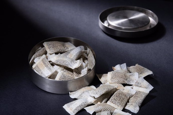 Archivo - Pimer plano de lata de snus sueco metálico con porciones blancas de bolsas de tabaco sin humo sobre un fondo oscuro