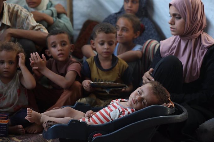 El niño palestino Abdulrahman abú al Jidyan, de once meses y diagnosticado con poliomielitis, recibe la atención de su madre y su familia en un campamento de desplazados al oeste de El Zauaida, en el centro de la Franja de Gaza (archivo)