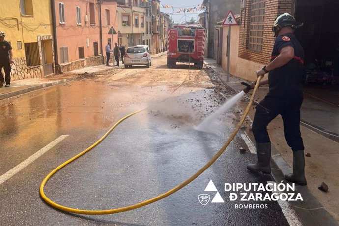 Los Bomberos de la Diputación Provincial de Zaragoza trabajan en la limpieza de las calles de Herrera de los Navarros (Zaragoza).