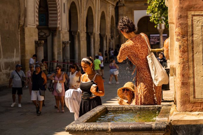 Turistas se refrescan con agua para hacer frente a las altas temperaturas registradas en la capital cordobesa, a 19 de agosto de 2024 en Córdoba (Andalucía, España).  