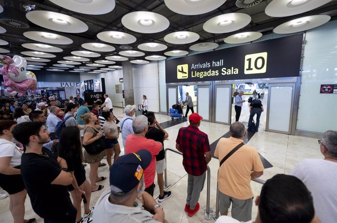 Varias personas esperan en la puerta de llegadas de la terminal T4 del aeropuerto Adolfo Suárez Madrid-Barajas, a 30 de agosto de 2024, en Madrid (España).  