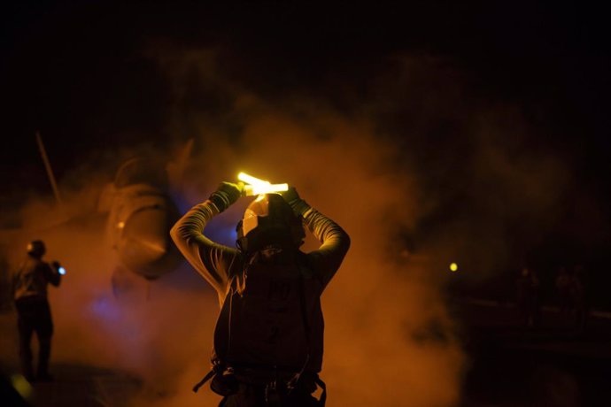 Archivo - January 22, 2024, Red Sea, United States: A U.S. Navy sailor signals a F/A-18F Super Hornet fighter jet to hold before a night-time launch off the flight deck of the Nimitz-class aircraft carrier USS Dwight D. Eisenhower in support of Operation 