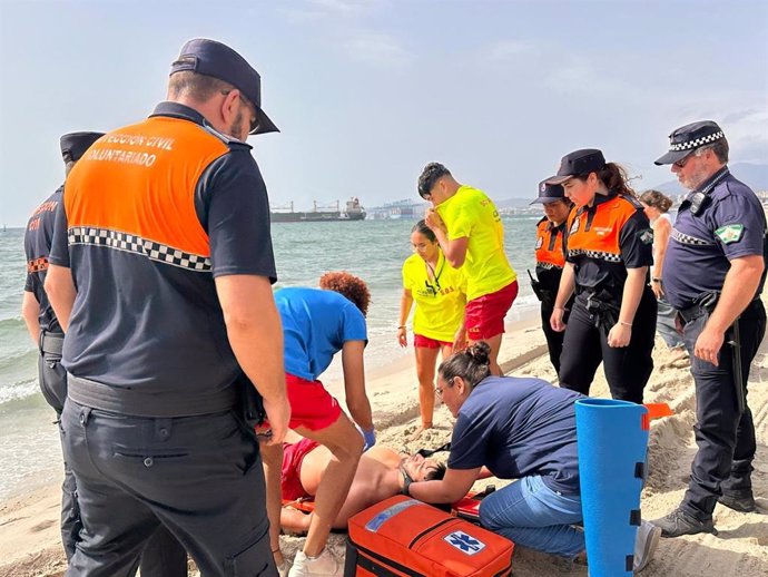 Personal de salvamento atendiendo a un bañista rescatado durante un simulacro realizado en la playa de Los Barrios