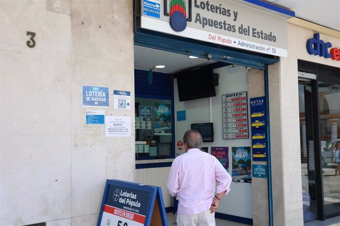 Una persona se dispone a adquierir un boleto en una Administración de Loterias