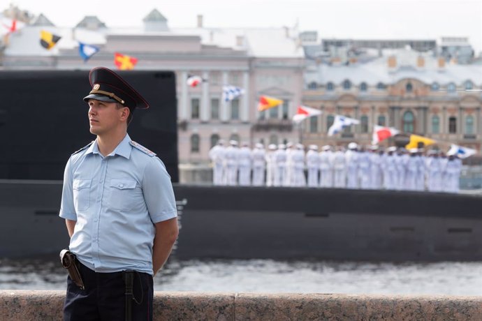 Archivo - July 28, 2024, St. Petersburg, Russia: Policeman stands on guard to maintain order on the Neva embankment with a submarine in the background during the annual Navy Day parade in St. Petersburg.