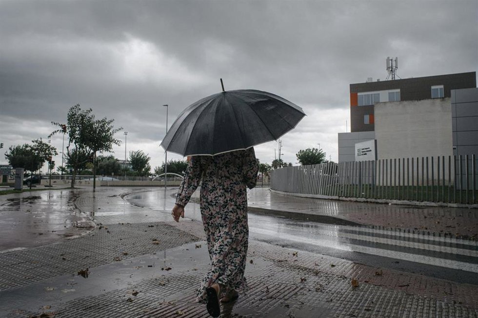Archivo - Una mujer camina bajo la lluvia en imagen de archivo en Castellón