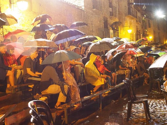 Espectadores asistentes a La Morisma de Aínsa resistiendo bajo sus paraguas la lluvia que provocó el final de la representación antes de tiempo.