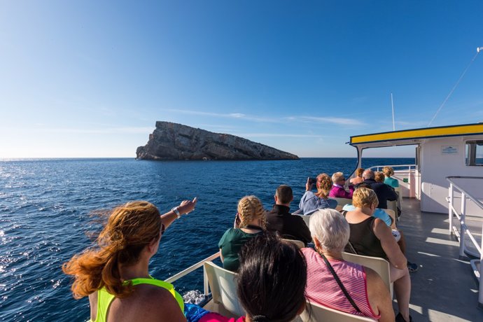 Archivo - Turistas con la isla de Benidorm al fondo