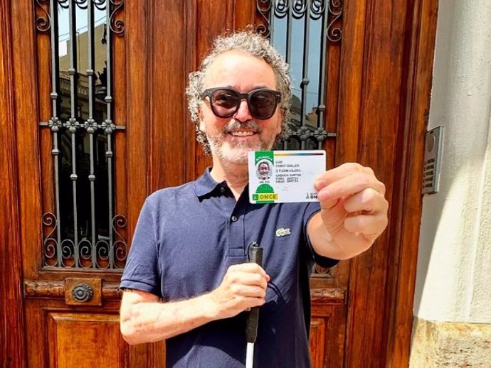 Luis Canut mostrando su carnet de afiliación a la ONCE.