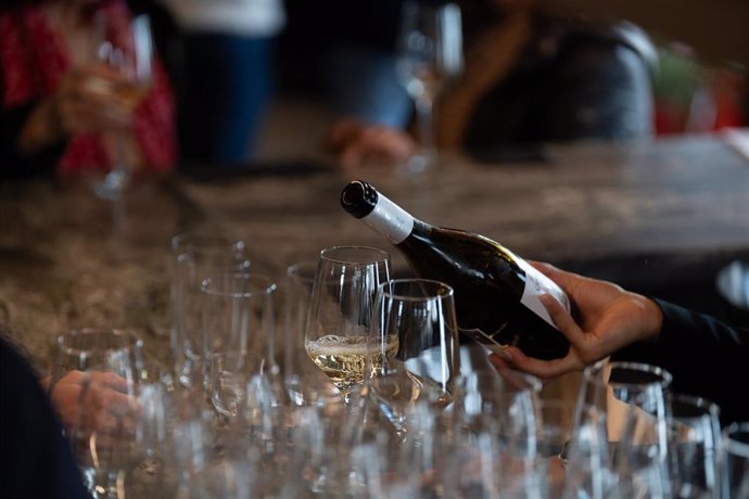 Archivo - Un camarero sirve copas de vino blanco en un bar.