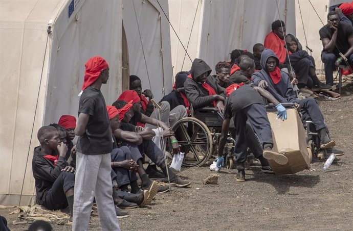 Varios migrantes esperan para ser trasladados al puerto de La Estaca,en El Hierro.