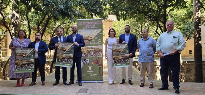 El delegado del Gobierno andaluz (1i), entre otros, con el cartel de la XIV Concentración de Rehalas 2024 de Cazalla de la Sierra.