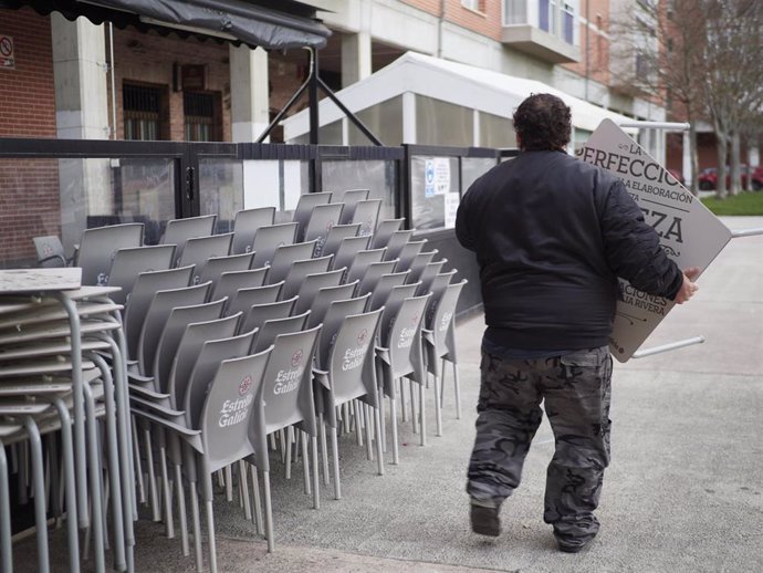 Archivo - Un camarero colocando las sillas de una terraza en Pamplona