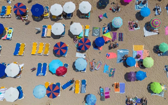 Archivo - Numerosas personas disfrutan de un día de playa.