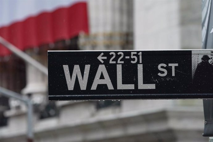 Archivo - 03 April 2020, US, New York: A Wall street sign is hanged near the facade of the New York Stock Exchange as stocks fall after the US reports job losses in March and on coronavirus fears.