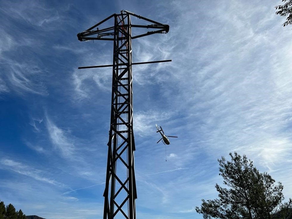 Archivo - Un helicóptero sobrevuela una de las torres de suministro eléctrico restablecidas en Mallorca.