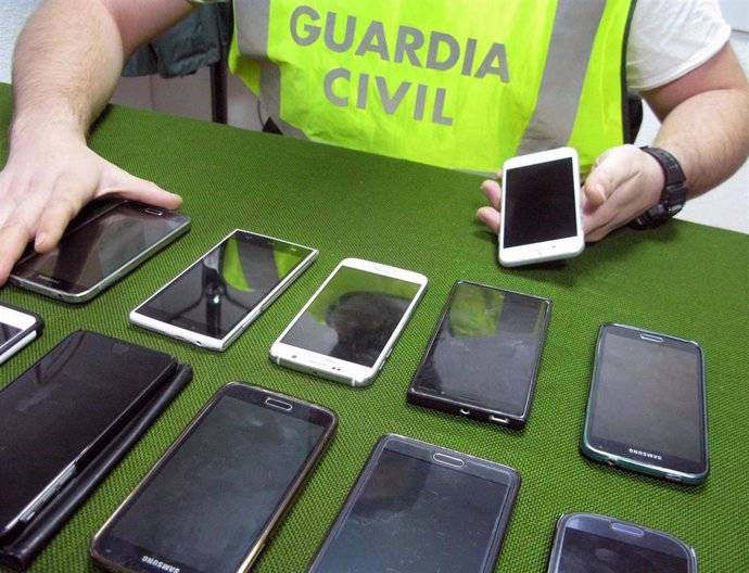 Archivo - Imagen de archivo de un guardia civil con varios móviles interceptados 