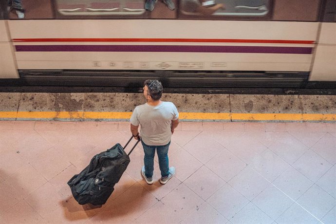 Archivo - Un hombre espera en el andén de un tren de cercanías en la estación Almudena Grandes-Atocha Cercanías