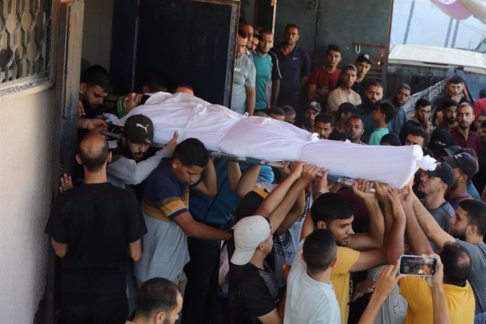 Palestinos trasladan el cadáver de un muerto en la morgue del Hospital Mártires de Al Aqsa tras un ataque del Ejército de Israel contra la ciudad de Deir al Balá, en el centro de la Franja de Gaza (archivo)