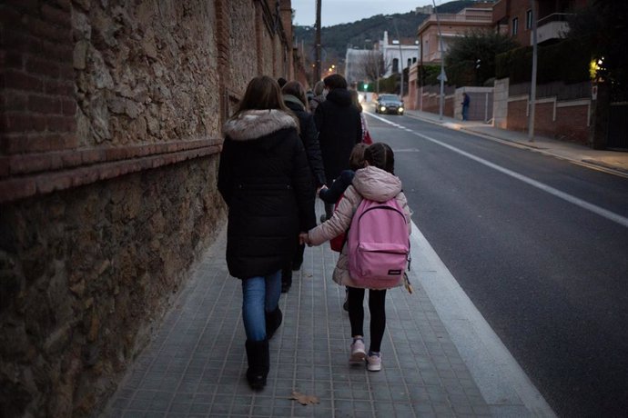 Imagen de archivo - Una mujer lleva de la mano a un niño