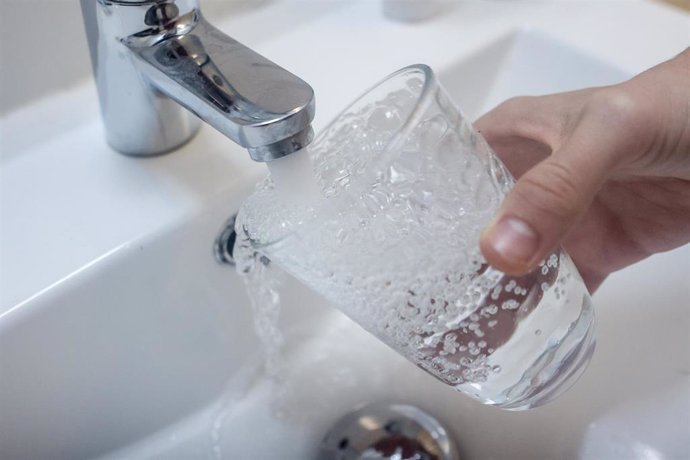 Archivo - Una persona llena un vaso de agua de un grifo. 