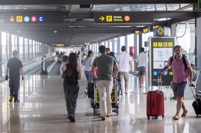 Varias personas con maletas en la terminal T4 del aeropuerto Adolfo Suárez Madrid-Barajas.