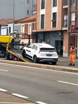 El taxi siendo retirado de la N-120 en La Virgen del Camino (León) tras protagonizar una persecución policial desde la capital