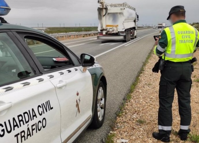 Un agente y un coche de la Guardia Civil de Tráfico.