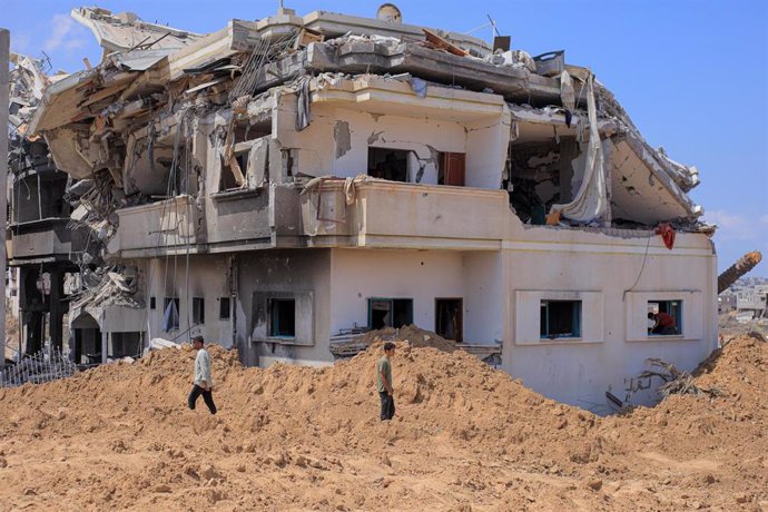 Palestinos frente a un edificio dañado por los ataques del Ejército de Israel contra Satar al Gharbi, al este de Jan Yunis, en el sur de la Franja de Gaza (archivo)