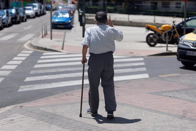 Archivo - Un hombre mayor pasea apoyándose en un bastón, a 24 de julio de 2023, en Madrid (España). 