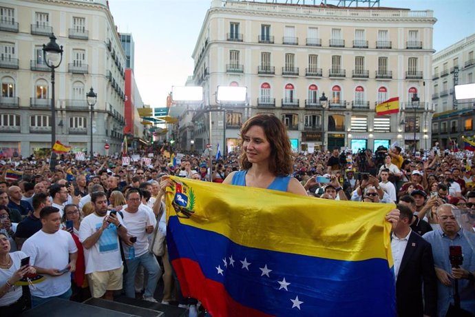 La presidenta de la Comunidad de Madrid, Isabel Díaz Ayuso, con la bandera de Venezuela durante una nueva protesta contra el Gobierno venezolano de Nicolás Maduro, en la Puerta del Sol, a 17 de agosto