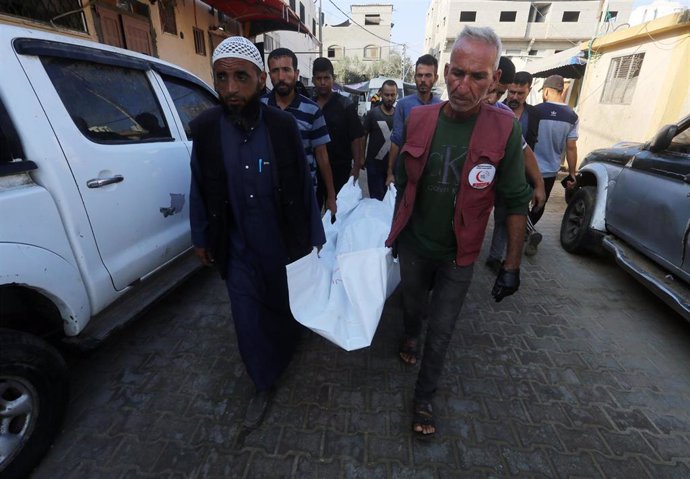 Familiares de un palestino muerto en un bombardeo del Ejército de Israel trasladan su cuerpo tras recuperarlo en la morgue del Hospital Mártires de Al Aqsa, en la ciudad de Deir al Balá, en el centro de la Franja de Gaza (archivo)