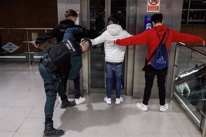 Archivo - Dos agentes de la Guardia Civil cachean a dos jóvenes en un control para prevenir la violencia entre bandas juveniles, en la estación de metro de Arganda del Rey, a 11 de febrero  de 2022,