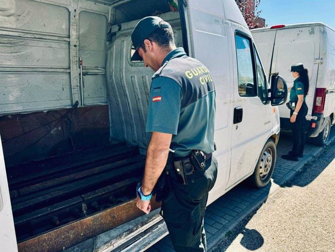 Agentes de la Guardia Civil junto a las furgonetas en las que se habían almacenado los raíles.