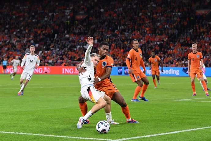 10 September 2024, Netherlands, Amsterdam: Germany's Florian Wirtz (L) and Netherlands' Jurrien Timber battle for the ball during the UEFA Nations League Group C soccer match between Netherlands and Germany at Johan Cruyff Arena. Photo: Federico Gambarini