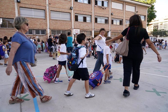 Niños y padres hacen cola para entrar al colegio el primer día de clase tras la vacaciones de verano.