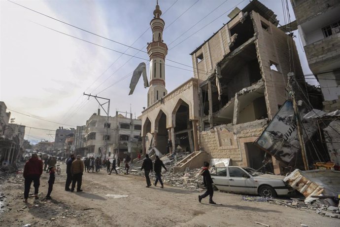 Archivo - Varios palestinos frente a la mezquita de Al Huda, situada en Rafá (sur) y dañada por los ataques ejecutados por el Ejército de Israel contra la Franja de Gaza (archivo)