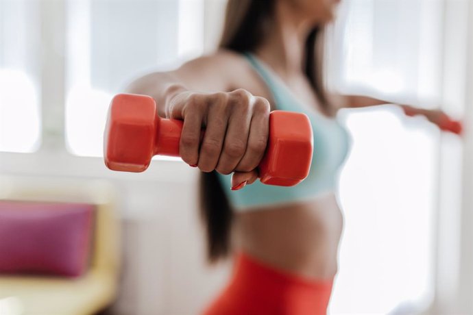 Archivo - Imagen de una mujer haciendo ejercicio con pesas.