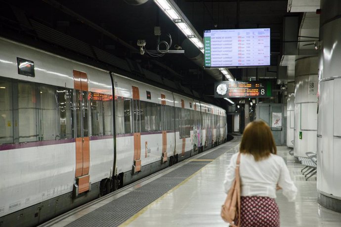 Archivo - Passatgera en una andana dels trens de Renfe Rodalies al juny, a Barcelona (Catalunya)