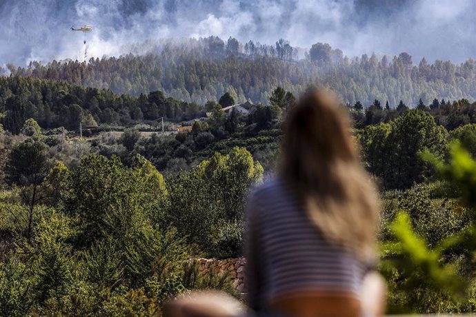 Una mujer observa el incendio forestal que comenzó en Simat, a 13 de septiembre de 2024