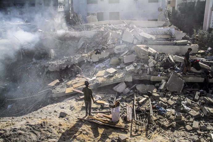 Palestinos inspeccionan sus casas destruidas después de que aviones israelíes atacaran un edificio residencial en el barrio de Sheij Radwan, en el oeste de Gaza.