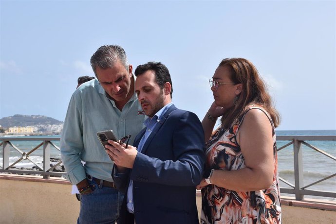 El diputado de Vox Javier Ortega Smith, este domingo en Ceuta mirando el móvil del presidente de Vox Ceuta, Juan Sergio Redondo.