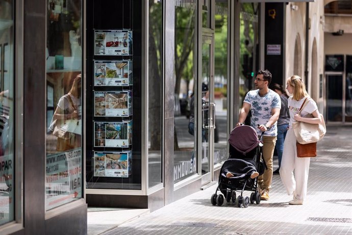 Archivo - Dos personas observan los anuncios de viviendas en venta en una inmobiliaria, a 15 de abril de 2024, en Palma de Mallorca, Mallorca, Baleares (España). El pasado 16 de abril, el Pleno del Parlament de las Illes Balears aprobó una Ley, provenient