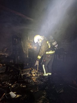 Un bombero trabaja en el incendio de una vivienda