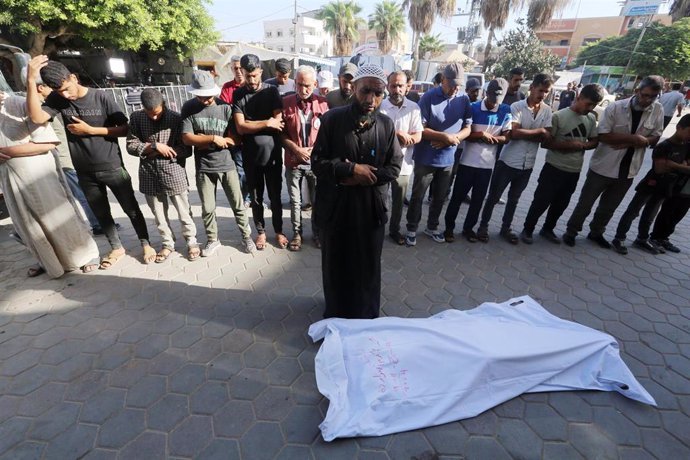 Palestinos rezan ante un muerto a causa de un ataque del Ejército de Israel tras recibir su cuerpo en la morgue del Hospital Mártires de Al Aqsa, en Deir al Balá, en el centro de la Franja de Gaza (archivo)