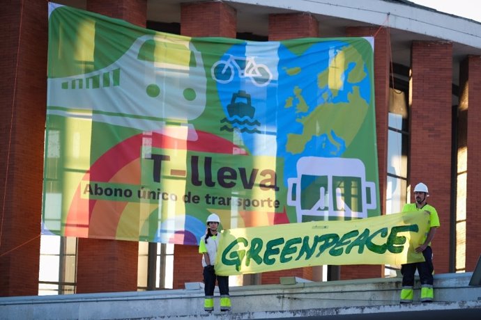 Greenpeace despliega una pancarta gigante en Atocha (Madrid) para reclamar un abono único de transportes.