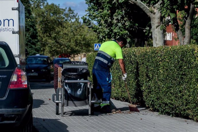 Un trabajador recogiendo hojas