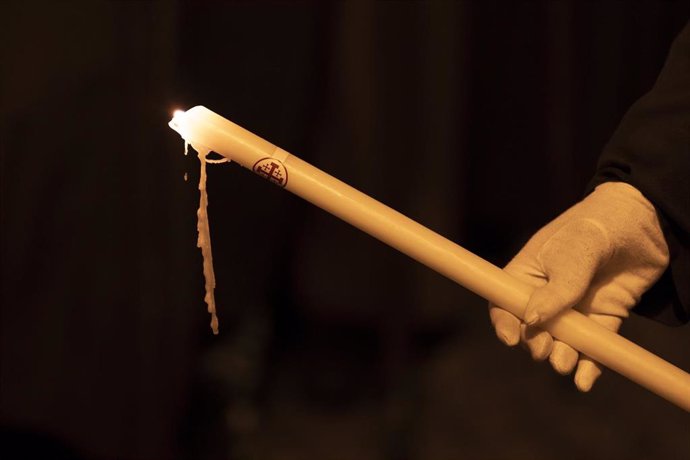 Archivo - Una persona sujeta una vela durante la procesión del Santo Entierro, a 29 de marzo de 2024, en Cuenca, Castilla-La Mancha (España). 