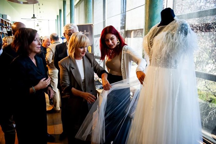 La consejera de Industria, Comercio y Empleo, Leticia García, observa un vestido de novia en la inauguración de las jornadas Uniendo Moda en Zamora.