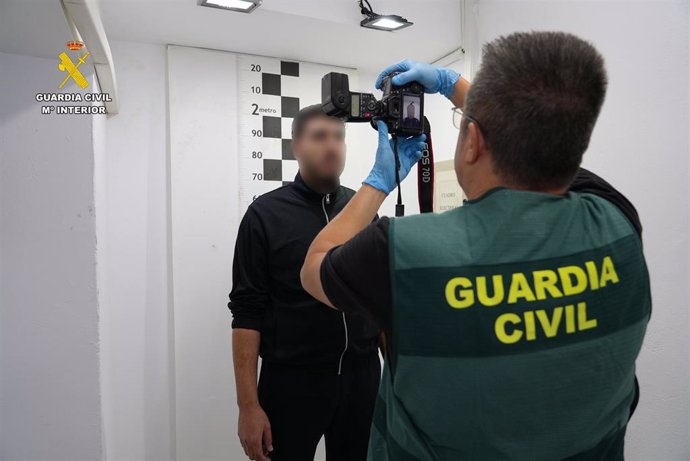 Un agente de la Guardia Civil toma fotografías al detenido, Karim E.B.